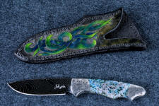 "Thuban" obverse side view in hot-blued 1095/nickel damascus blade, hand-engraved 304 stainless steel bolsters, Shattuckite gemstone handle, hand-carved, hand-dyed leather sheath "Thuban" obverse side view in hot-blued 1095/nickel damascus blade, hand-engraved 304 stainless steel bolsters, Shattuckite gemstone handle, hand-carved, hand-dyed leather sheath